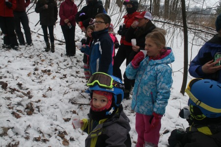 Kids enjoying a sample of sap and finished syrup